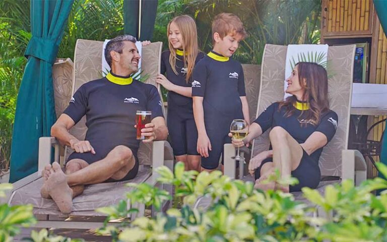 family of four in loungers near pool at discovery cove orlando