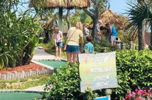 family playing mini golf at adventure landing shipwreck island waterpark