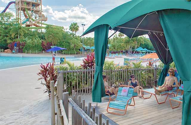 family seated on chairs in cabana near beach area at aquatica water park orlando