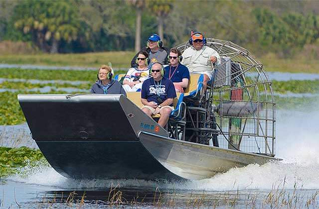 fanboat with a tour group speeding across wetlands at kissimmee swamp tours