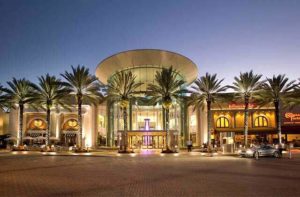 front exterior with lighting and palm trees at night at mall at millenia orlando