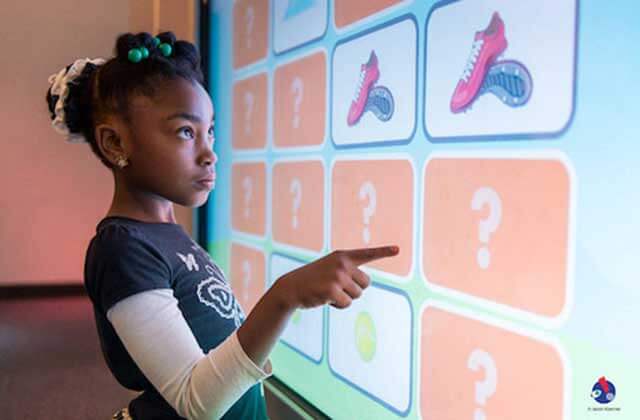 girl plays game on interactive touch screen exhibit at miami childrens museum florida