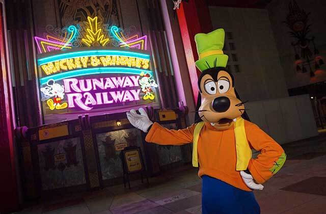 goofy character pointing to runaway railway neon sign at disneys hollywood studios theme park orlando
