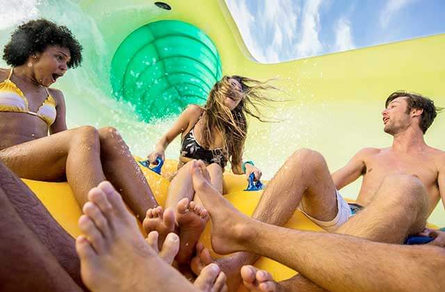 group of excited young people on raft ride at universals volcano bay water park orlando