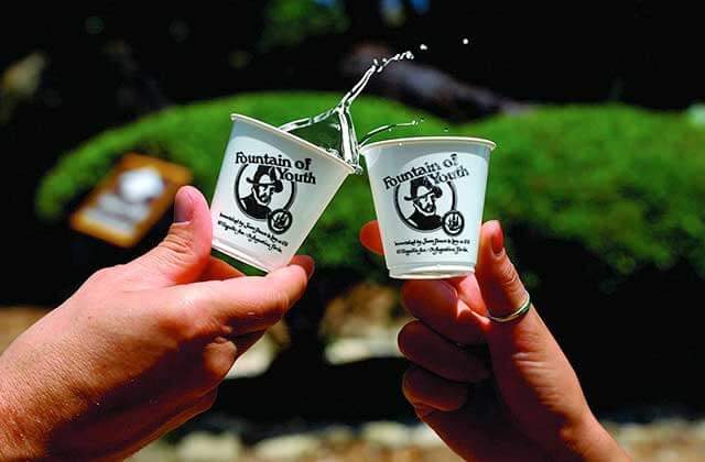 hands holding sample cups with spring water at ponce de leons fountain of youth st augustine