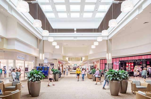 indoor atrium corridor with potted plants and shoppers at cordova mall pensacola florida