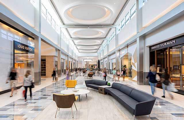 indoor shopping corridor with sofas chairs tables and storefronts at town center at boca raton florida