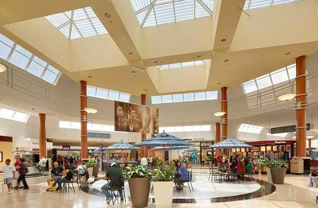 interior atrium with shoppers seated and stores at miami international mall florida
