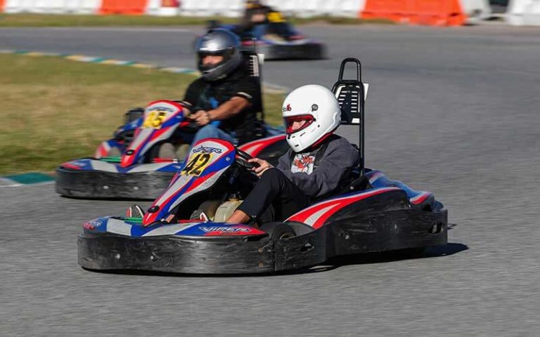 kart racers in helmets speeding past on track at orlando kart center