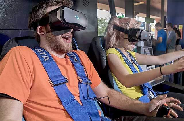 man and woman seated with vr headsets and harnesses laughing at off the wall gamezone coconut creek florida