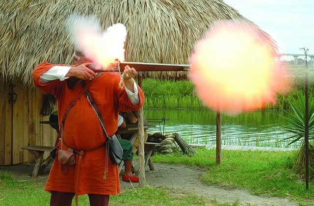 man in pioneer costume fires musket at ponce de leons fountain of youth st augustine