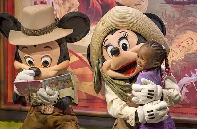 mickey and minnie with safari theme signing autograph and hugging girl at disneys animal kingdom theme park orlando