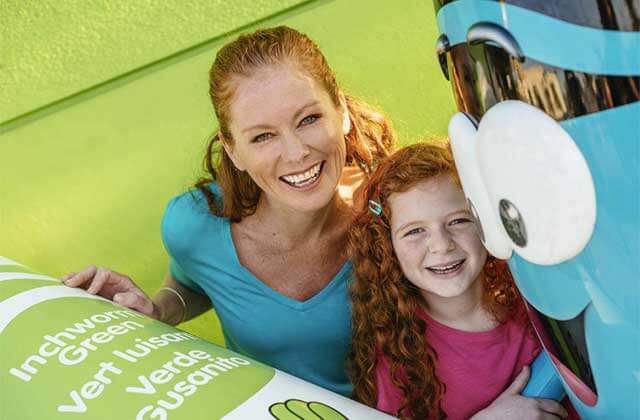 mother and daughter smiling with a crayon character at crayola experience orlando