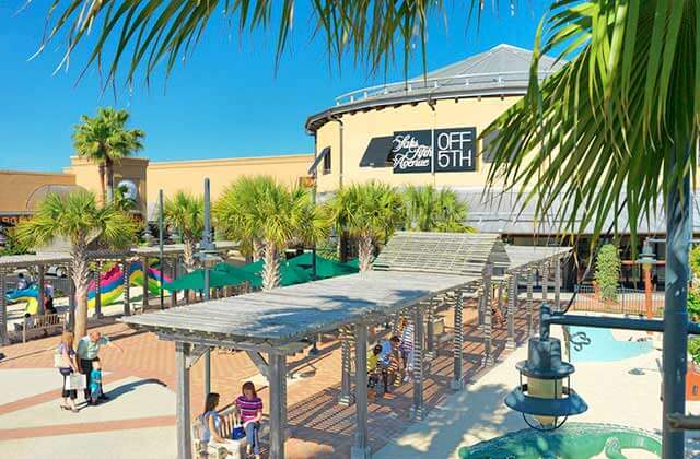 patio area with shoppers seated and saks off 5th storefront at silver sands premium outlets miramar beach