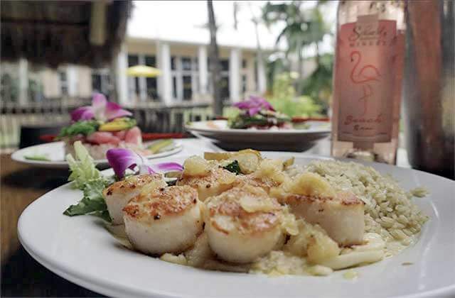 plate with scallops entree and wine bottle with outdoor seating at schnebly redlands winery brewery restaurant homestead