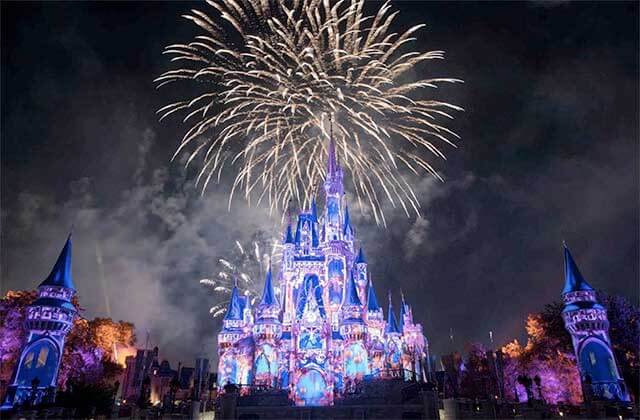 projected lighting on castle with fireworks display at night at disney magic kingdom theme park orlando