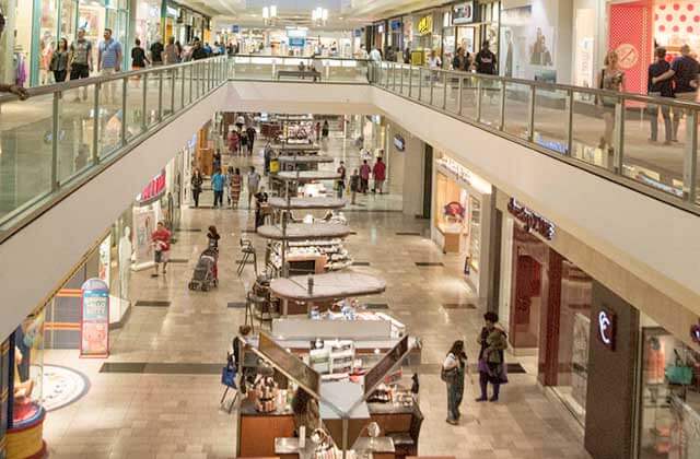 row of kiosks in a corridor with shoppers at the avenues mall jacksonville