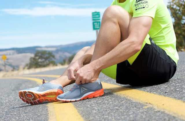 runner sitting on road ties shoe at reebok outlets orlando