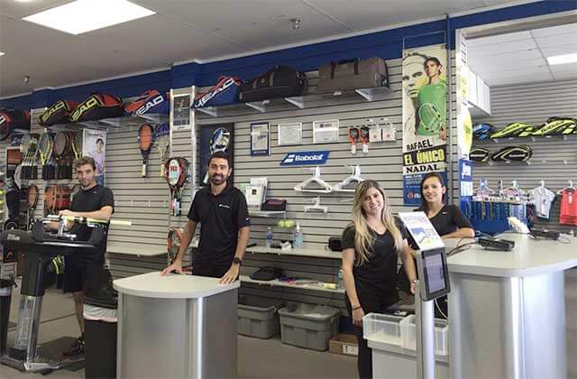 smiling employees in the equipment service area at tennis plaza florida stores