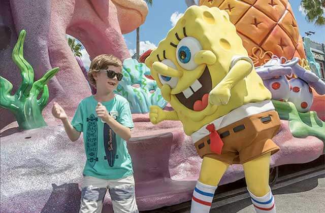 spongebob character dancing with a boy in a parade at universal studios florida theme park orlando