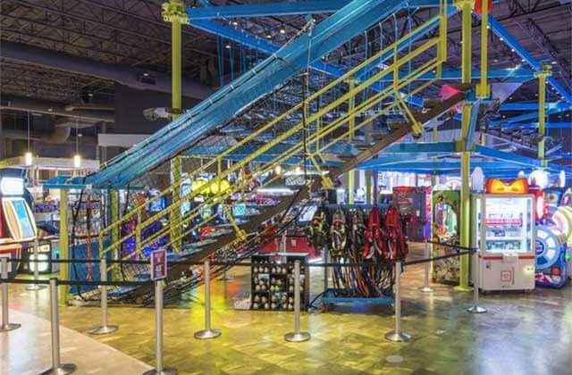 staircase to mezzanine with ropes course and neon lighting at main event entertainment orlando