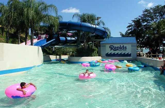 swimmers in inner tubes on a lazy river with water slides above at rapids water park west palm beach