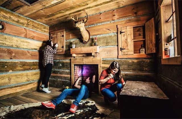 teens looking for clues in a cabin themed room at the escape game orlando