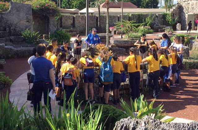 tour guide with a large student group in a courtyard at coral castle sculpture garden museum homestead