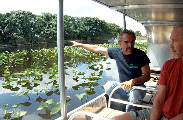 tour guide points while speaking from an airboat at everglades holiday park ft lauderdale