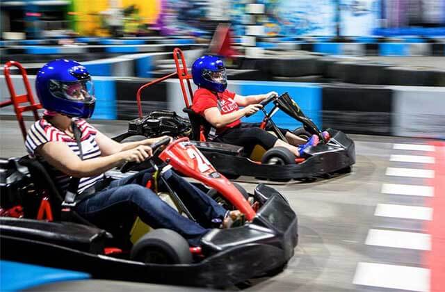 two boys racing go karts on indoor track at xtreme action park ft lauderdale