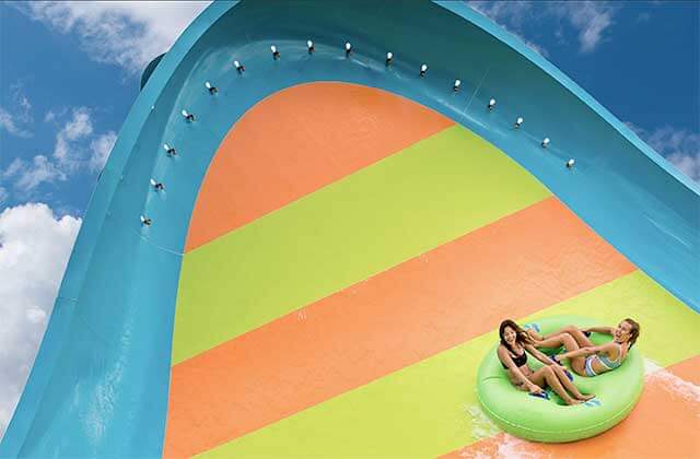 two girls in a tube ride up a steep ramp at aquatica water park orlando