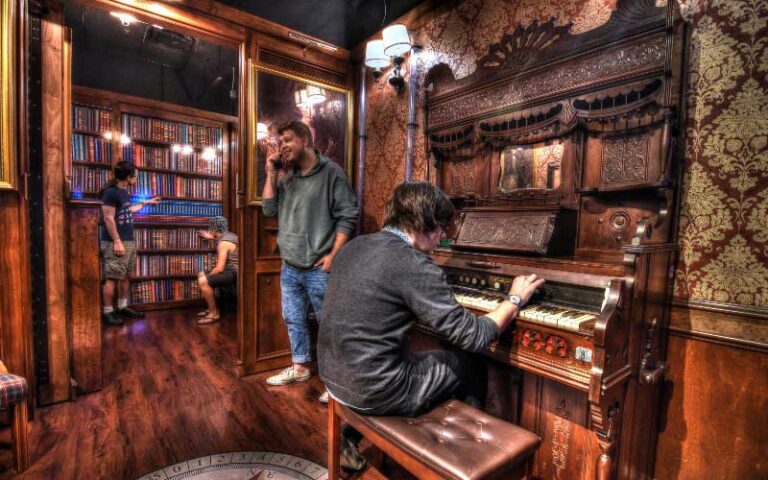 two men in room with old piano at escapology orlando