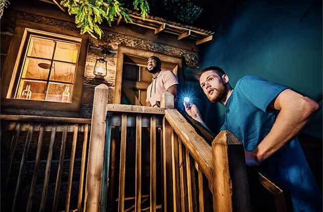 two men climbing stairs of rustic cabin themed area at the escape game orlando