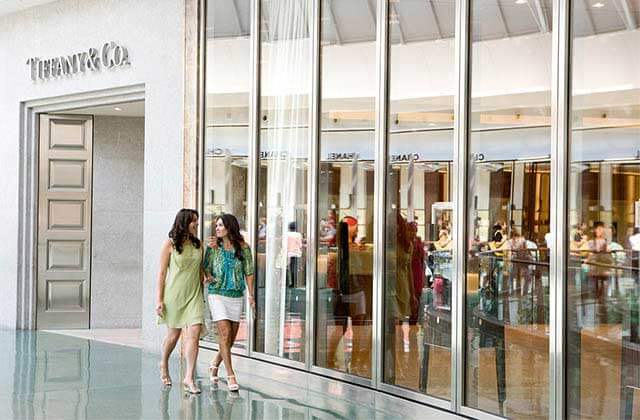 two young ladies walking along storefronts at mall at millenia orlando