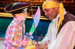 volunteer boy waves his sword at a pirate performer at pirates dinner adventure orlando