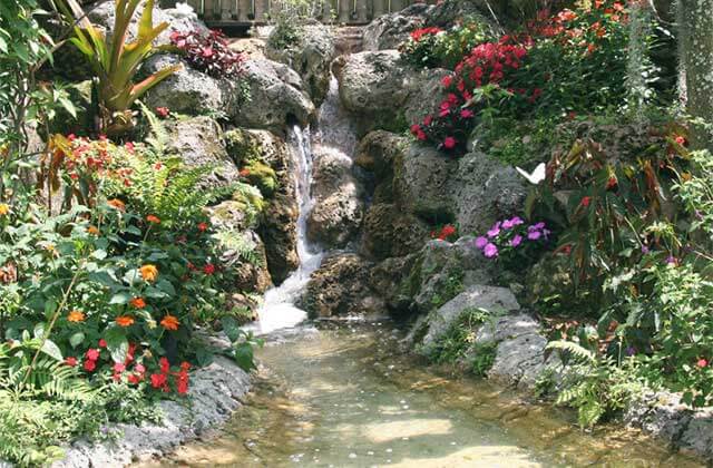 a water feature trickles down a landscaped rock at butterfly world coconut creek