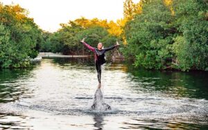 woman doing acrobatics on dolphin in river at theater of the sea islamorada