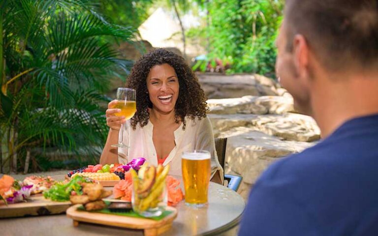 woman laughing with wine and fruit on table at discovery cove orlando