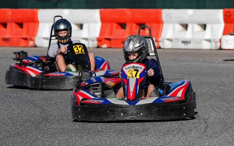 young kart racers in helmets racing around along track at orlando kart center