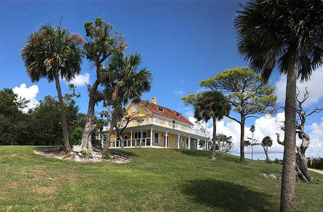 historic yellow home on a hilltop with palms at playalinda beach canaveral national seashore