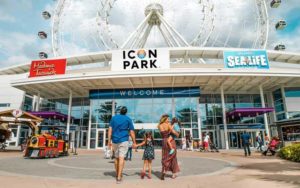 family of four walking to entrance of icon park with observation wheel above from enjoy a day at icon park post