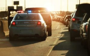 police car with lights on pulled over behind pickup truck with traffic from unique florida traffic laws post