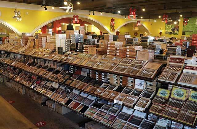 aisles of cigar products in a store with yellow and white decor at corona cigar company orlando