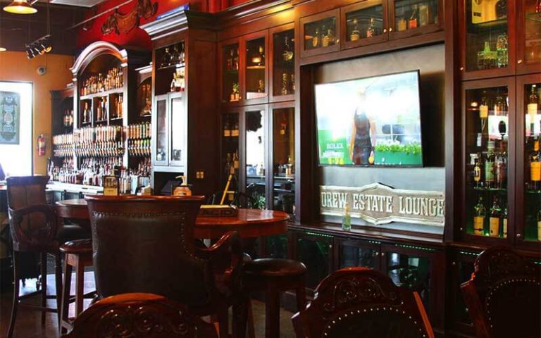 bar area with wood and leather furniture and shelves at corona cigar orlando