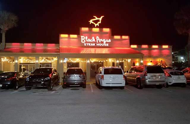 front exterior with red lighting at night of restaurant at black angus steakhouse orlando