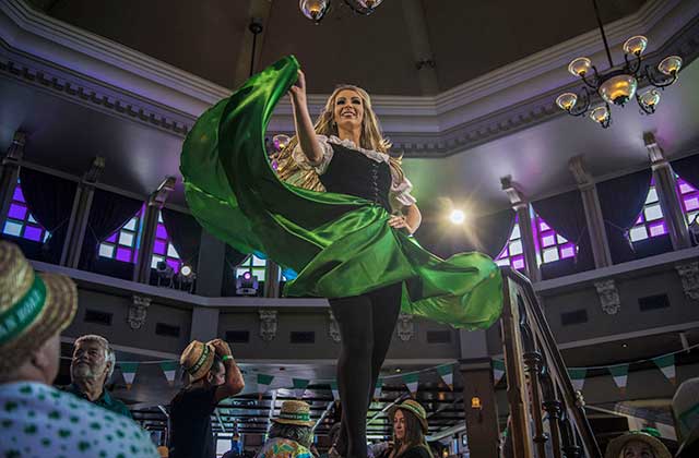irish dancer in a green dress on stage amid diners at tables in raglan road at disney springs lake buena vista orlando