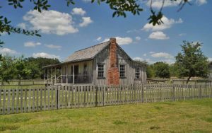 old timey cottage with fence and chimney at pioneer village