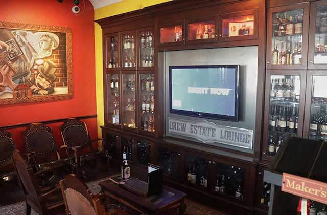 swanky lounge area with liquor cabinets and tv screen at corona cigar company orlando