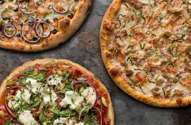 three pizzas with a variety of toppings at flippers pizzeria orlando kissimmee