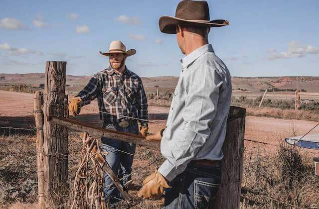 two cowboys standing by fence at boot barn kissimmee